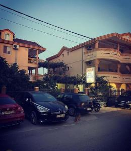 a couple of cars parked in front of a house at Apartments Dalila in Ulcinj