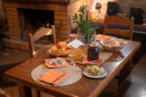 a wooden table with food and fruit on it at Casa da Ramada in Campo do Gerês