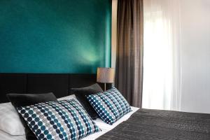 a bedroom with a bed with blue and white pillows at Hotel Perła in Kraków