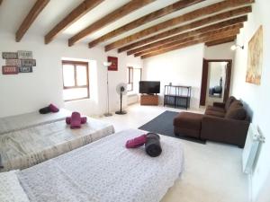 una sala de estar con dos camas y un sofá en CAL SENYOR DAMIÀ, en Santanyí 42 fotos más