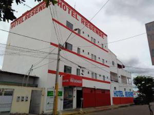 a white and red building with a red garage at Hotel Resende in Imperatriz