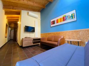 a bedroom with a bed and a chair and a tv at El Cuartel de Santa María in Santa María de la Alameda