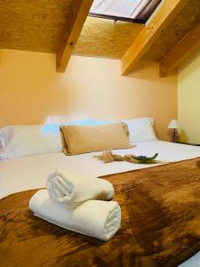a large bed with two white towels on it at El Cuartel de Santa María in Santa María de la Alameda