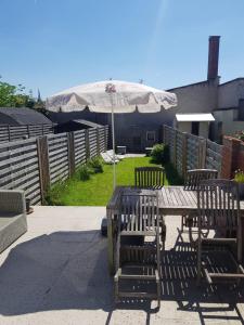 a wooden table and chairs with an umbrella at Home Bruges Cosy Comfort Modern Couple Privacy walking distance City center Kitchen Terrace Garden in Bruges