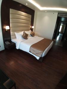 un grande letto in una camera d'albergo con due lampade di Hotel DVIJ INN a Jaipur