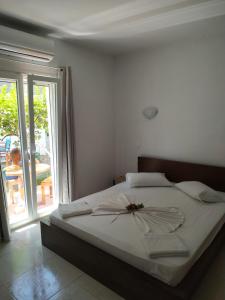 Ekaterini Apartments في جوفيا: غرفة نوم عليها سرير مع وردة