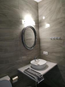 łazienka z umywalką i lustrem w obiekcie Ekaterini Apartments w Gouvii +37 zdjęć