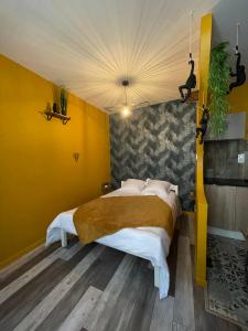 a bedroom with a large bed with yellow walls at JuNgLe ROOM in Romans-sur-Isère