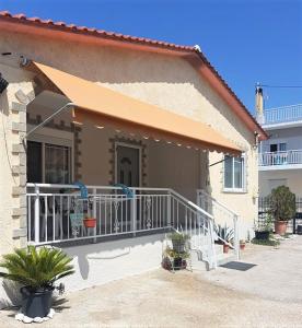 a house with a porch and a balcony with plants at Sia Beach House in Néa Karváli