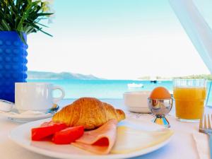 a table with a plate of food and a glass of orange juice at Klima Paradise in Klíma