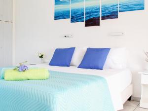 a bedroom with a bed with blue and white pillows at Klima Paradise in Klíma