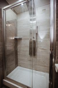a shower with a glass door in a bathroom at Wanderlust Relais Vaticano in Rome