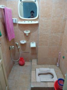 a bathroom with a shower with a toilet and a mirror at Hotel Tour De Swat in Swat