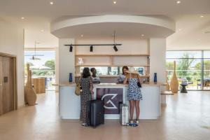 two women standing at a kitchen counter with luggage at Golden Tulip Porto-Vecchio in Porto-Vecchio