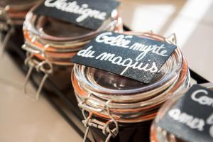 a group of glass jars with labels on them at Golden Tulip Porto-Vecchio in Porto-Vecchio