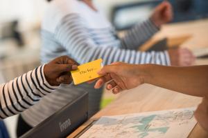 a person handing another person a piece of paper at Golden Tulip Porto-Vecchio in Porto-Vecchio