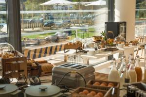 a room with a table with food and a large window at Golden Tulip Porto-Vecchio in Porto-Vecchio
