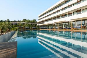 a swimming pool in front of a building at Golden Tulip Porto-Vecchio in Porto-Vecchio