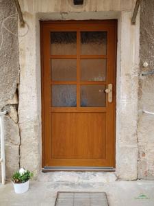 una porta in legno in un edificio in pietra con una pianta in vaso di FeWo "Am Teich" a Kreischa