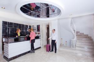 伊斯坦布尔City Center Hotel Taksim İstanbul的男人和女人站在酒吧里,带着手提箱