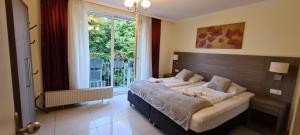 a bedroom with a bed and a large window at Hotel Cara Vita Cologne in Cologne