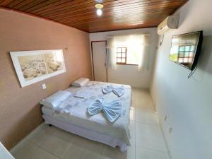 a bedroom with a bed with blue bows on it at Pousada Praiana in Pipa