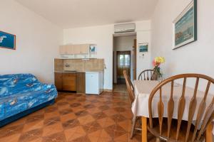 a living room with a dining room table and a kitchen at Apartments Laura in Dramalj