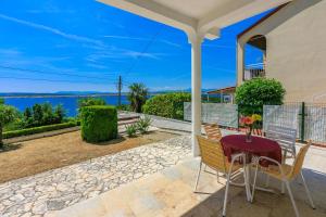 a table and chairs on a porch with a view of the ocean at Apartments Laura in Dramalj