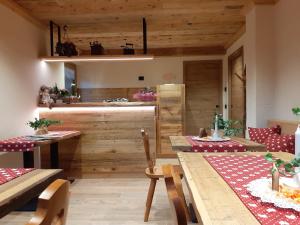 a dining room with wooden walls and a table and chairs at B&B IL BUCANEVE in Santo Stefano di Cadore