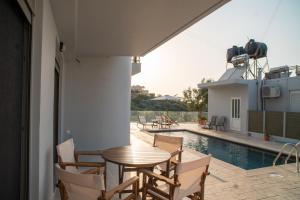 a patio with a table and chairs next to a pool at Hello Village Chania in SFakianalíon