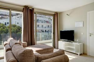 a living room with a couch and a flat screen tv at Atico Albamar in Puerto de Mogán