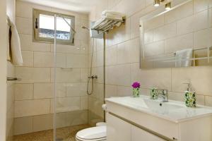 a bathroom with a toilet and a sink and a shower at Atico Albamar in Puerto de Mogán +14 photos