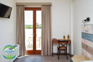 a room with a desk and a sliding glass door at La Posidonia - Villa Abele in Marsala