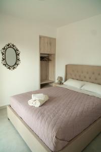 1 dormitorio con 1 cama grande y espejo en la pared en Hello Village Chania en SFakianalíon