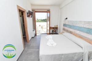 a bedroom with a white bed and a balcony at La Posidonia - Villa Abele in Marsala