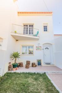 a white house with a potted plant in front of it at Green House in Baleal