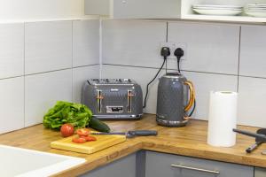 eine Küchentheke mit einem Schneidebrett und einem Toaster in der Unterkunft CADeS accommodation in Wolverhampton