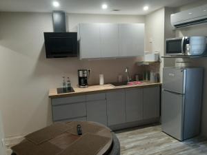 a kitchen with a sink and a refrigerator and a table at 3 Apt T2 COSY de 40 à 50 M2 Idéal pour un déplacement PRO " Les IRIS " in Bourg-Saint-Andéol +107 photos