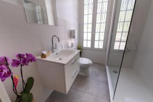 a white bathroom with a sink and a toilet at Hotel La Bonne Auberge in Saint-Martin-Vésubie +69 photos