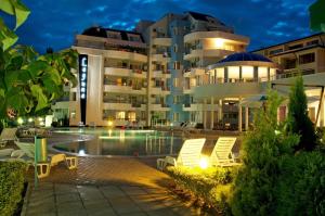un hotel con piscina y sillas frente a un edificio en PMG Laguna Apartments, en Sunny Beach