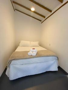 a bedroom with a bed with two towels on it at Pousada Cocar Caraíva in Caraíva