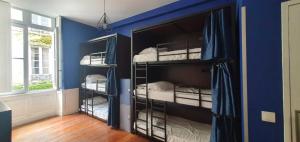 una camera con 4 letti a castello in una camera blu di HOSTEL20 Bordeaux HIFRANCE a Bordeaux