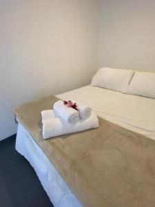 a bed with folded towels on top of it at Pousada Cocar Caraíva in Caraíva