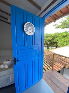 a blue door with a sign on it at Pousada Cocar Caraíva in Caraíva
