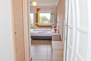 a bedroom with a bed and a window at Hotel Stella in Skala Rachoniou