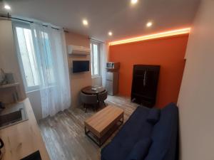 sala de estar con sofá azul y TV en 3 Apt T2 COSY de 40 à 50 M2 Idéal pour un déplacement PRO " Les IRIS ", en Bourg-Saint-Andéol