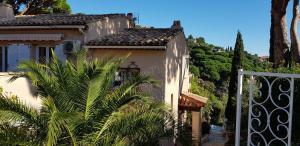 una casa con una palma di fronte a un cancello di Mas Saint Jaume a Cavalaire-sur-Mer