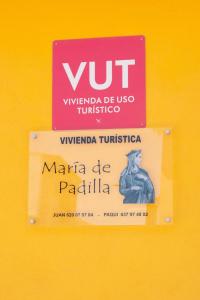 a sign on a yellow wall with a vnt sign at Vivienda turística María de Padilla in Montiel