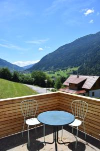 einen Tisch und zwei Stühle auf einem Balkon mit Bergblick in der Unterkunft Haus Hoen in Untertweng