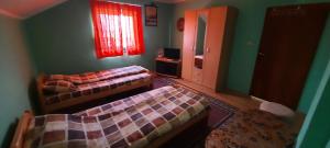 a bedroom with two beds and a window and a mirror at Sobe Seka in Golubac